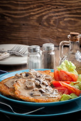Crispy fried homemade potato pancakes with mushroom sauce.