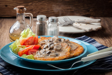 Crispy fried homemade potato pancakes with mushroom sauce.