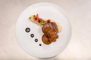 Pepper steak, served with potatoes, strawberry and cherry tomato