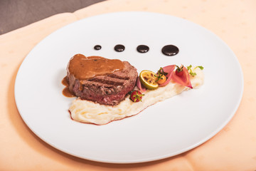 Pepper steak, served with potatoes, strawberry and cherry tomato