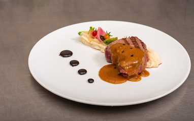 Pepper steak, served with potatoes, strawberry and cherry tomato