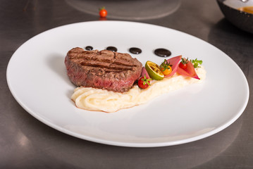 Pepper steak, served with potatoes, strawberry and cherry tomato