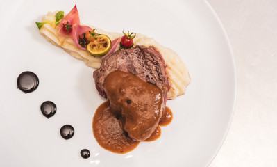 Pepper steak, served with potatoes, strawberry and cherry tomato