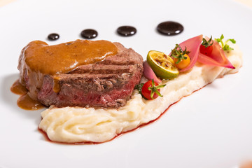 Pepper steak, served with potatoes, strawberry and cherry tomato