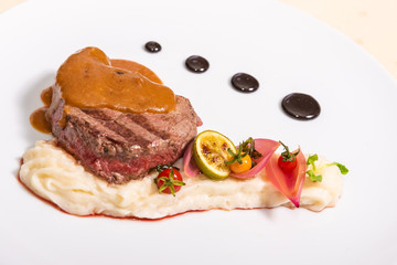 Pepper steak, served with potatoes, strawberry and cherry tomato