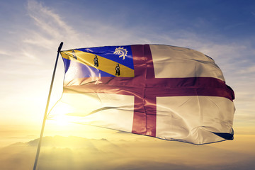 Herm flag textile cloth fabric waving on the top sunrise mist fog