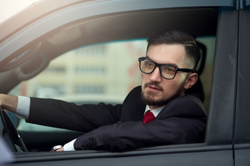Successful businessman driving luxury car.