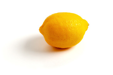 One yellow lemon, isolated on white background, light on the right.
