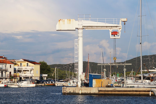 Crane lift for raising boats in the marina ACI Jazera in Croatia. Dalmatian ragion of Adriatic sea at Mediterranean area. The ships moored in the port of a quiet fishing town in a sunny,clear day.