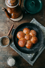 Buns and bread baking on dark wooden background. Food styling and cooking with fresh ingredients.