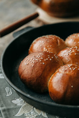 Buns and bread baking on dark wooden background. Food styling and cooking with fresh ingredients.