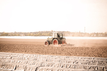 Traktor f&auml;hrt durch Feld