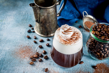 Autumn espresso drink ideas, Irish coffee cocktail with whipped cream and cocoa, blue concrete background copy space