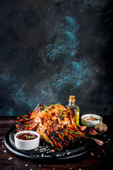 Grilled meat concept. bbq pork ribs with barbeque sauce, olive oil. fresh herbs on dark wooden background copy space - obrazy, fototapety, plakaty