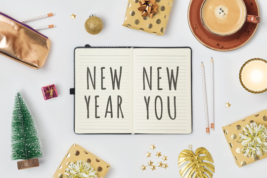 New Year resolutions concept with notepad and gift boxes on white background