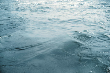 Water surface with ripples and sunlight reflections