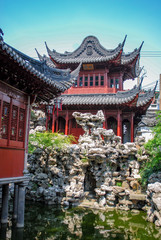 Fototapeta na wymiar Pagoda home on rocks over a pond in Shanghai China.