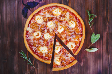 pizza mozzarella with cheese and tomatoes on a wooden background