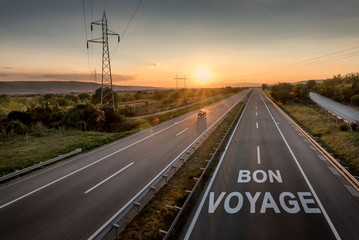 Beautiful Countryside Motorway with a Single Car at sunset with motivational message Bon Voyage
