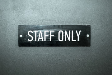STAFF ONLY - inscription in white letters on black frame on grey door