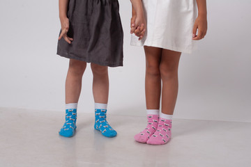 legs of two little girlfriends in knitted socks in a white studio