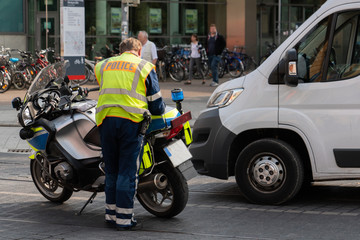 Fototapeta na wymiar Road policeman fines a van driver for breaking traffic rules