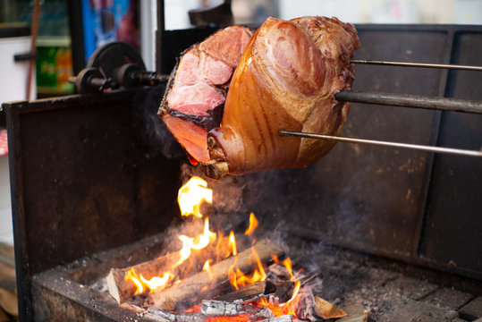 Delicious Hole Pork Ham Roasting On Wood Fire At A Czech Christmas Market In Prague  - 2