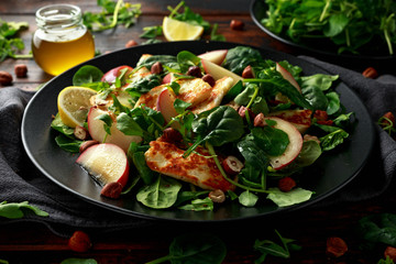 Grilled Halloumi Cheese salad with peach fruit, nuts and spinach, arugula mix. healthy food