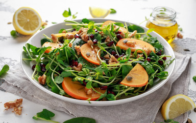 Persimmon and pea shoot salad with walnuts, pomegranate and pumpkin seed