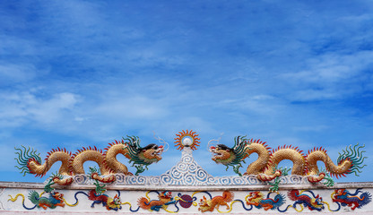 Chinese dragon and deva statue on the chinese temple roof with blue sky background