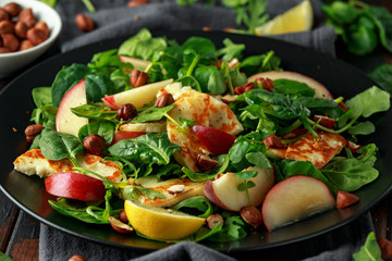 Grilled Halloumi Cheese salad with peach fruit, nuts and spinach, arugula mix. healthy food. closeup
