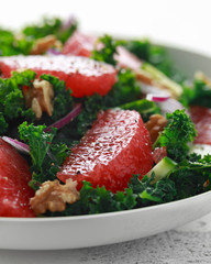Healthy vegan, vegetarian Grapefruit kale salad with walnuts, red onion and cucumber