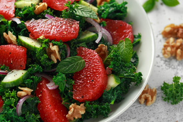 Healthy vegan, vegetarian Grapefruit kale salad with walnuts, red onion and cucumber