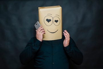 The concept of emotions. A man listens to a message on his mobile phone. Looks lovers eyes. Left hand raised to the head. On the face smile and happiness.