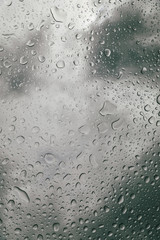 Glass with water drops under the heavy cloudy sky.