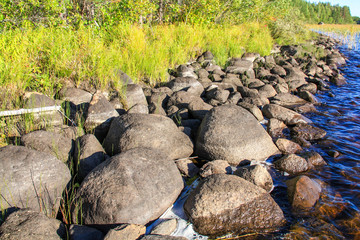 Fototapeta na wymiar Large boulders on the shore of a large lake in Karelia