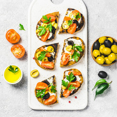 Olives cherry tomatoes goat cheese bruschetta. Top view, space for text.