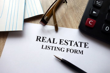 Real estate listing form with pen, calculator and   glasses in office