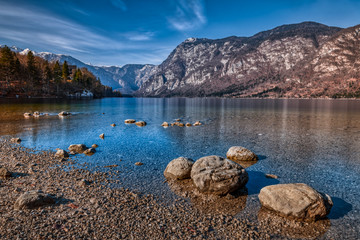 The tranquil Bohinj Lake in Slovenia surrounded by rocky peaks