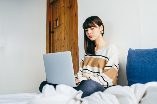 Woman using laptop in bed