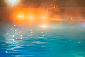 Steam over  warm pool in the winter outdoors. Spa salon. Out of focus due to dense white fumes.