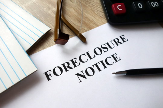 Foreclosure Notice With Pen, Calculator And   Glasses In Office