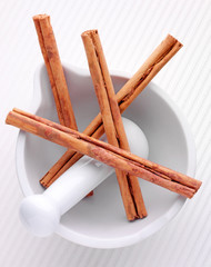CINNAMON STICKS IN PESTLE AND MORTAR