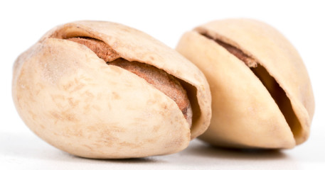 two pistachios on a white background