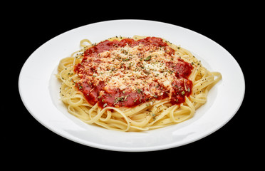 close in meal of noodles with red sauce and grated cheese on white plate, black background
