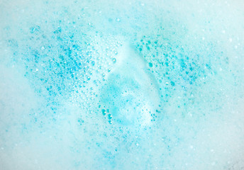 View of foam after dissolving color bath bomb in water, closeup