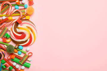 Flat lay composition with different yummy candies and space for text on color background