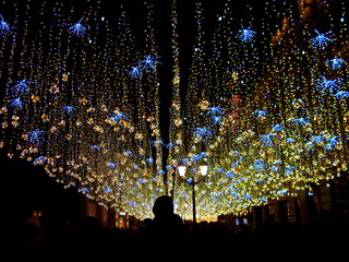 Moscow, Russia, holiday lights in the sky. Downtown district is decorated to New Year, Christmas and holidays. Festive illuminations on Nikolskaya street at winter night.