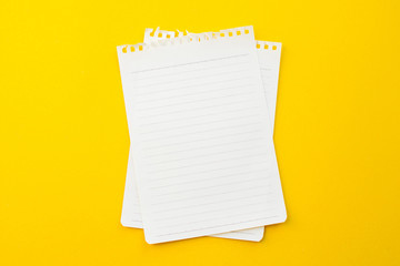 empty paper of notebook on yellow background with school concept.