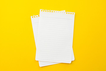 empty paper of notebook on yellow background with school concept.